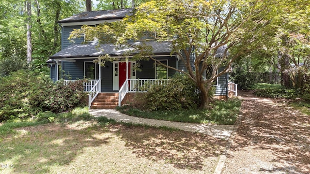 view of front of house with covered porch and a shingled roof