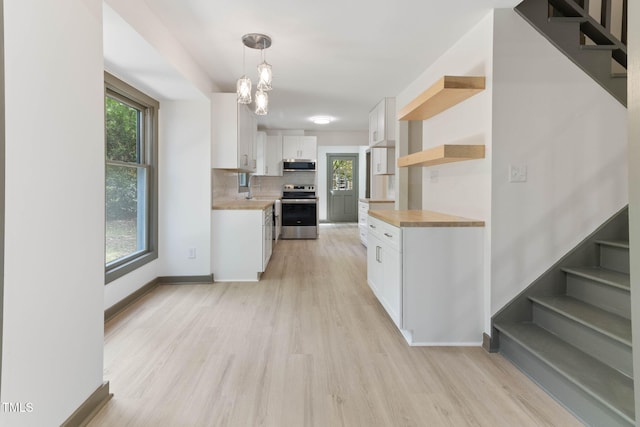 kitchen featuring appliances with stainless steel finishes, open shelves, wooden counters, white cabinets, and light wood-style floors