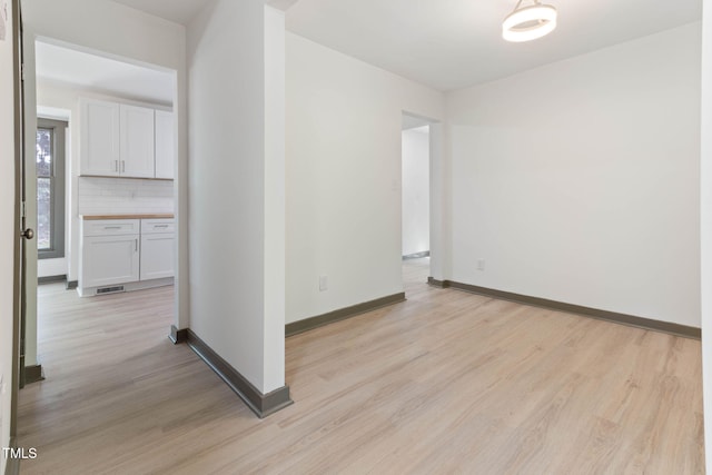empty room with light wood-type flooring and baseboards