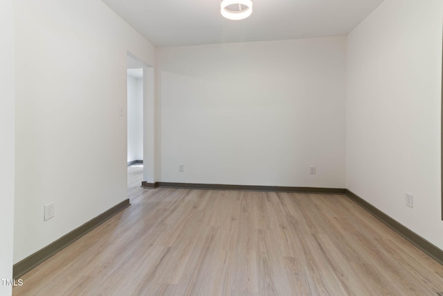 empty room with light wood finished floors and baseboards