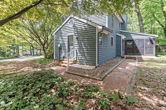 view of outdoor structure with entry steps and a sunroom