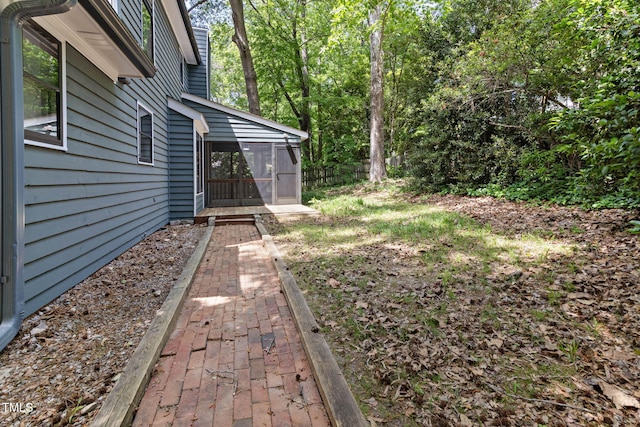 view of yard featuring a sunroom and fence