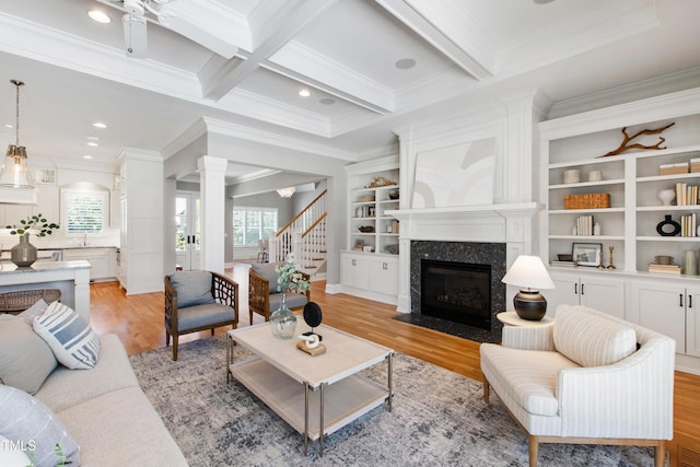 6 Castlewood Dr, Durham, NC 27713 - living area featuring decorative columns, crown molding, light wood-style floors, a fireplace, and stairway