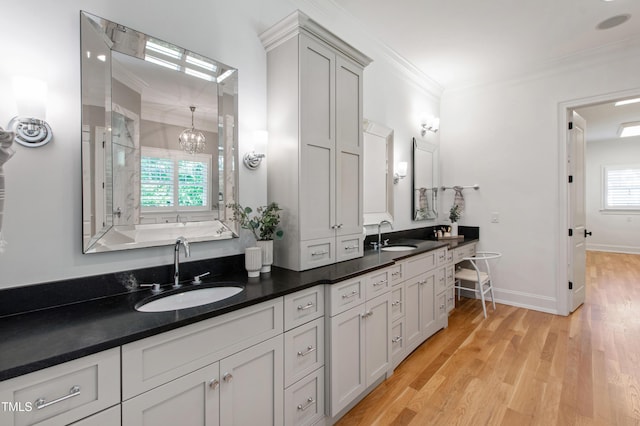 6 Castlewood Dr, Durham, NC 27713 - full bath with wood finished floors, ornamental molding, double vanity, a chandelier, and baseboards