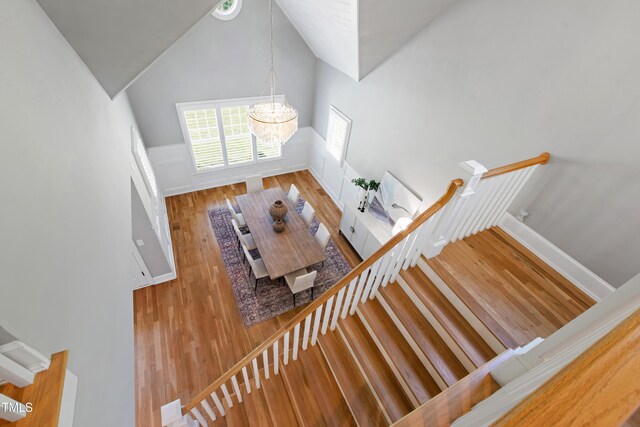 6 Castlewood Dr, Durham, NC 27713 - stairs featuring a chandelier, wood finished floors, wainscoting, and lofted ceiling