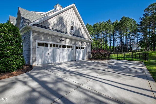 6 Castlewood Dr, Durham, NC 27713 - view of side of home with a garage, fence, driveway, and roof with shingles