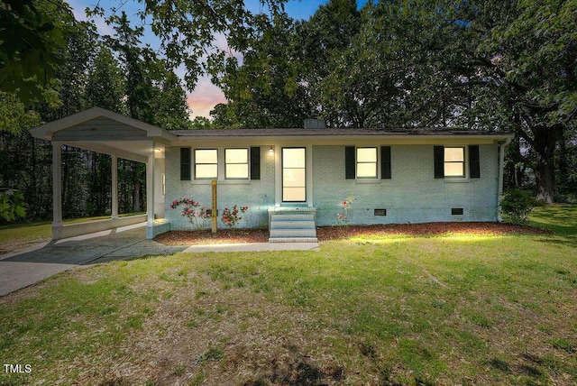 ranch-style house with brick siding, a front yard, entry steps, crawl space, and driveway