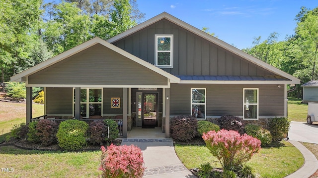 109 Rustler Rd, Louisburg, NC 27549 - craftsman-style house with a porch, board and batten siding, a standing seam roof, a metal roof, and a front lawn
