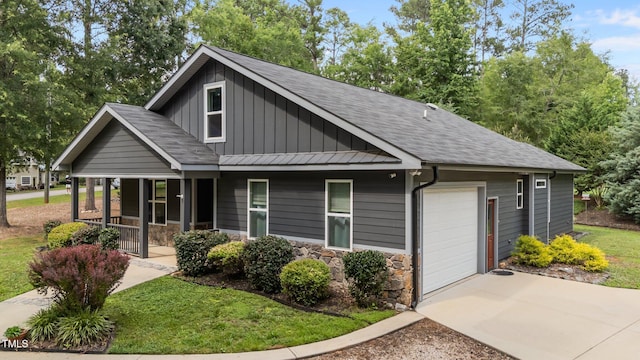 109 Rustler Rd, Louisburg, NC 27549 - view of front of home featuring covered porch, board and batten siding, concrete driveway, and stone siding