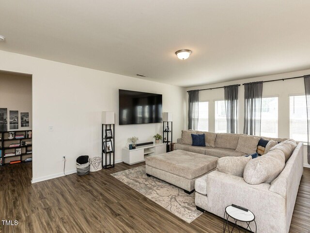 living room with baseboards and dark wood-type flooring