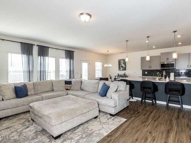 living area with recessed lighting, a chandelier, and dark wood-type flooring