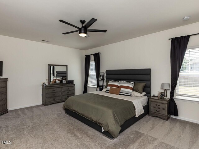 carpeted bedroom featuring baseboards, visible vents, and ceiling fan