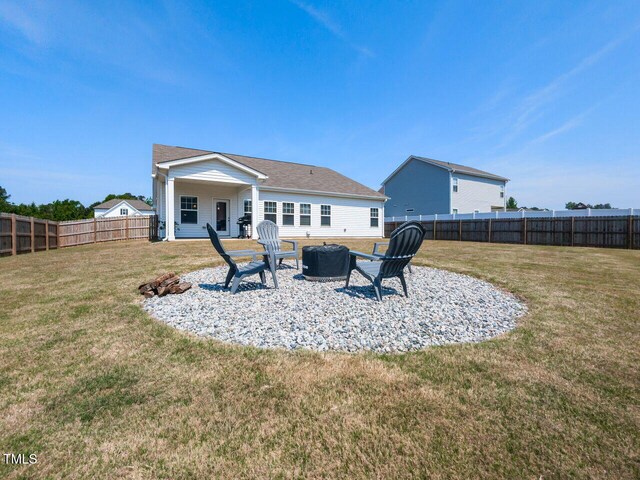 back of property featuring a yard, a patio, a fenced backyard, and an outdoor fire pit