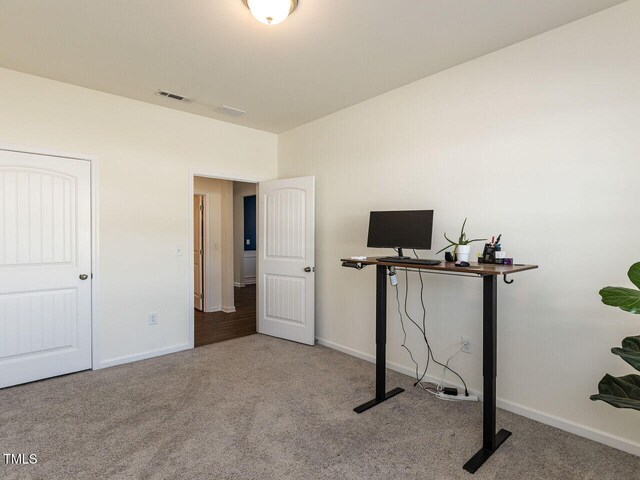 unfurnished office featuring baseboards, carpet flooring, and visible vents