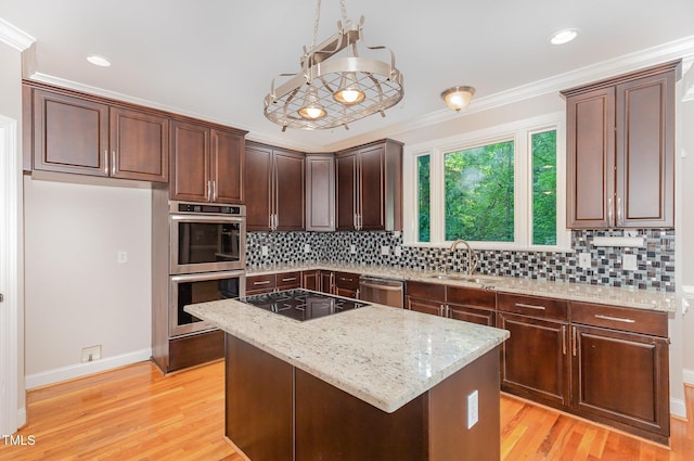 kitchen with a sink, appliances with stainless steel finishes, backsplash, and light stone counters