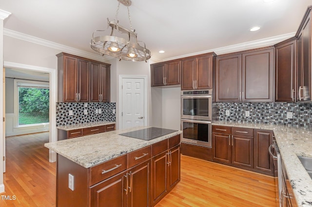 kitchen with backsplash, crown molding, light stone counters, light wood finished floors, and stainless steel appliances