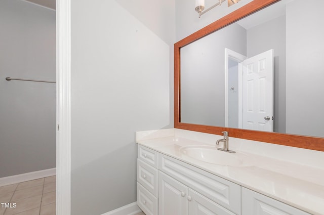 bathroom with baseboards, tile patterned flooring, and vanity