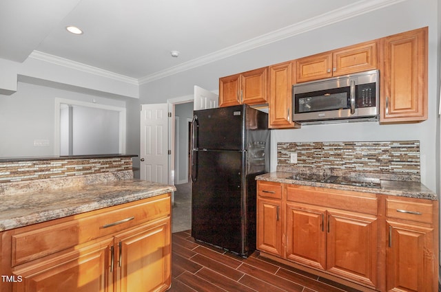 kitchen with dark wood-style flooring, crown molding, tasteful backsplash, black appliances, and stone counters