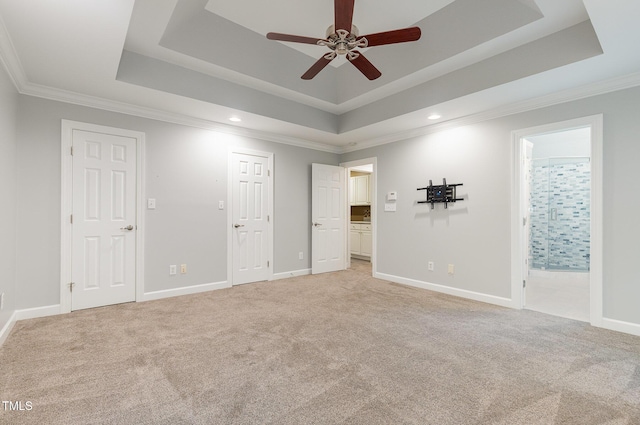 unfurnished bedroom featuring light colored carpet, recessed lighting, and a raised ceiling