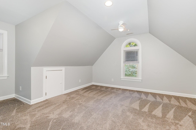 additional living space featuring carpet flooring, a ceiling fan, baseboards, and vaulted ceiling