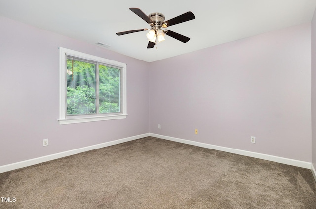 spare room with a ceiling fan, baseboards, visible vents, and carpet