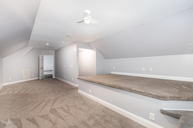 additional living space with visible vents, lofted ceiling, baseboards, a ceiling fan, and carpet