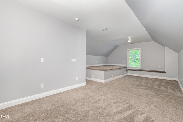 bonus room with baseboards, lofted ceiling, and light colored carpet
