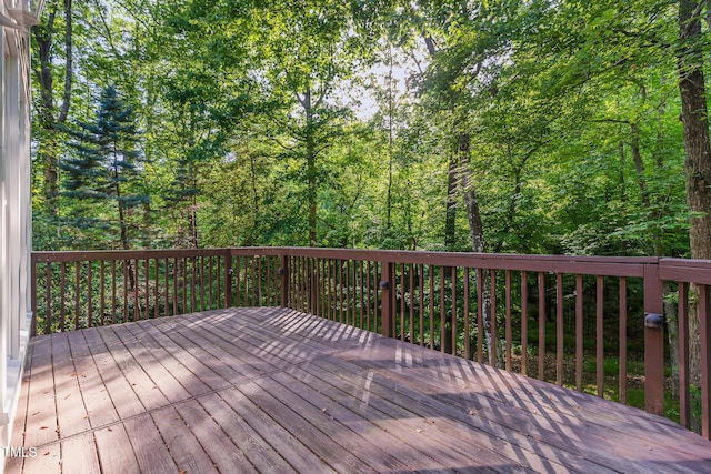 wooden terrace featuring a wooded view