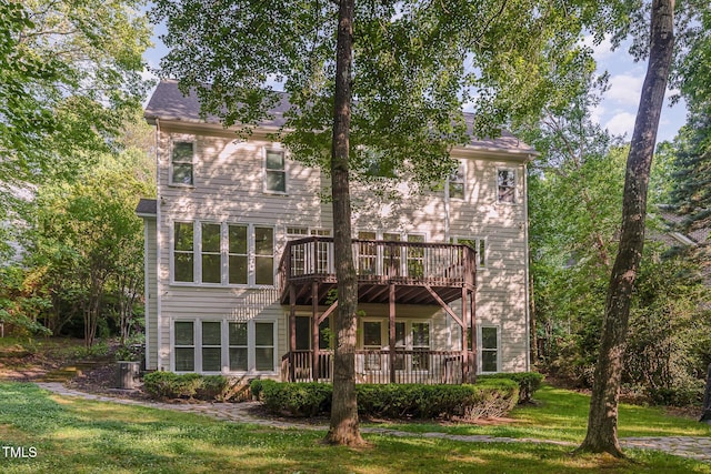 back of property featuring a lawn and a wooden deck