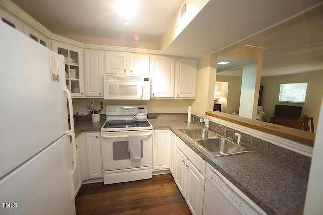 kitchen featuring white appliances, glass insert cabinets, dark wood-type flooring, white cabinets, and a sink