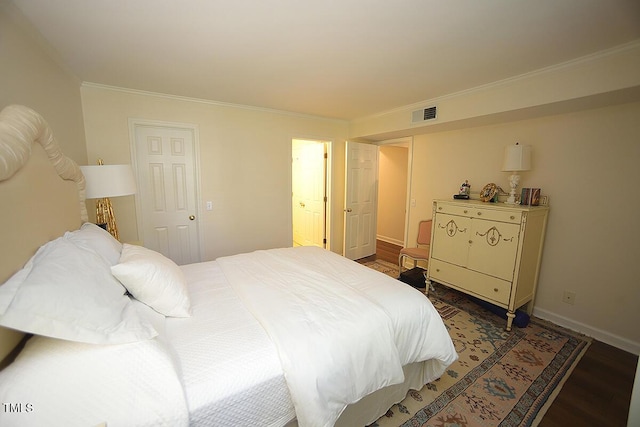 bedroom with crown molding, baseboards, visible vents, and wood finished floors