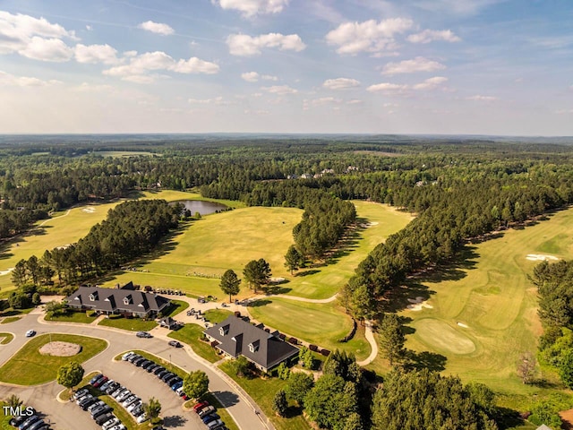 drone / aerial view with view of golf course, a water view, and a forest view
