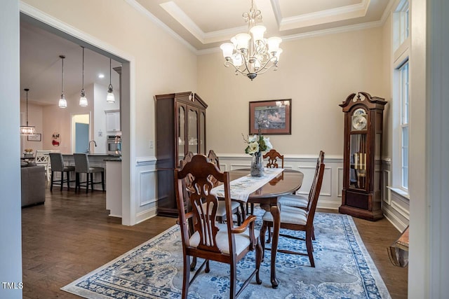 dining space featuring ornamental molding, wainscoting, dark wood-style floors, a chandelier, and a wealth of natural light