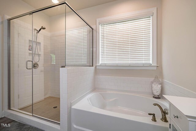 bathroom featuring a stall shower and a bath