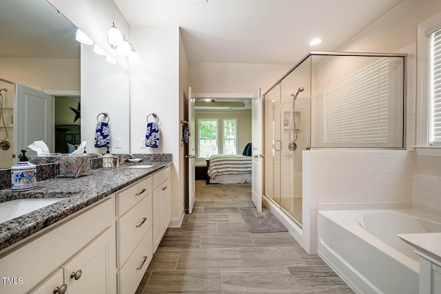 ensuite bathroom with a sink, ensuite bath, double vanity, a shower stall, and a bath