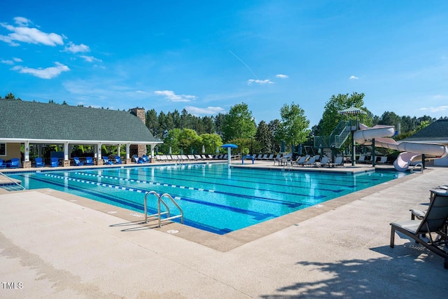 pool with a patio area and a water slide