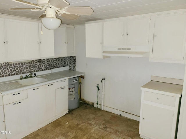 kitchen featuring white cabinets, tile patterned floors, under cabinet range hood, and light countertops