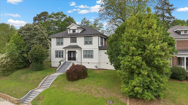 view of front of home with stairs, a front lawn, and stucco siding