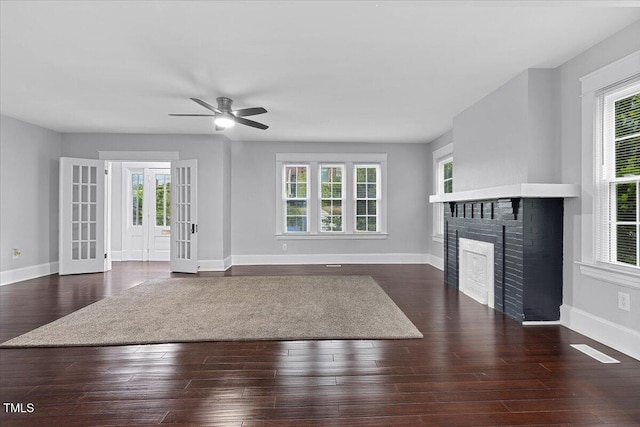 unfurnished living room with baseboards, a fireplace, and a ceiling fan