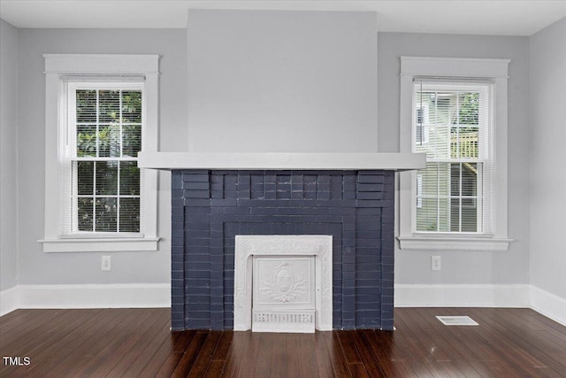 interior details with baseboards, a fireplace, and wood finished floors