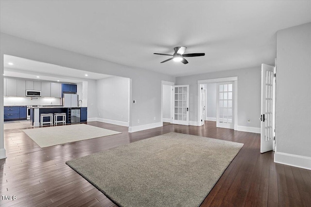 unfurnished living room featuring a ceiling fan, french doors, dark wood-style flooring, baseboards, and recessed lighting