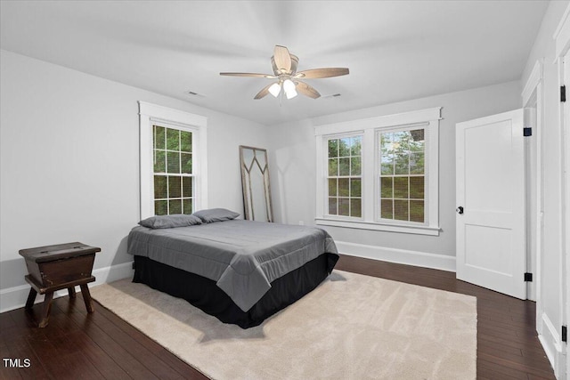 bedroom featuring baseboards, ceiling fan, dark wood-style flooring, and visible vents