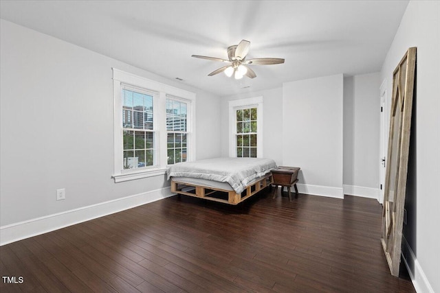 bedroom with baseboards, ceiling fan, and wood finished floors