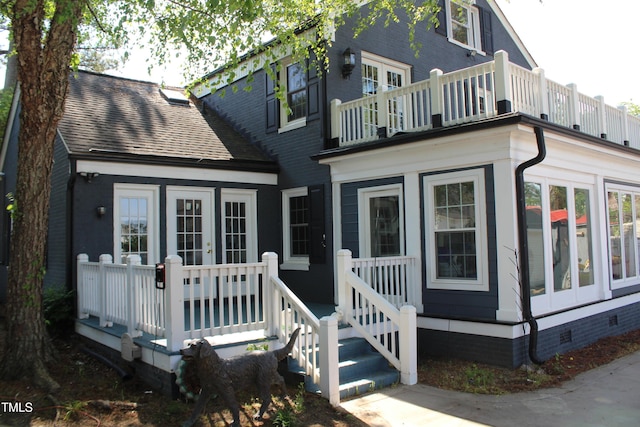 view of front of house featuring french doors, a shingled roof, crawl space, and a balcony