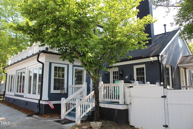 view of front of house featuring crawl space, a chimney, a gate, fence, and a shingled roof