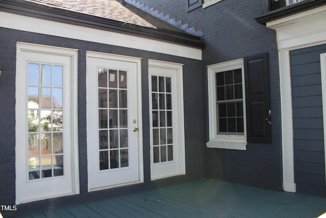entrance to property with brick siding and a deck