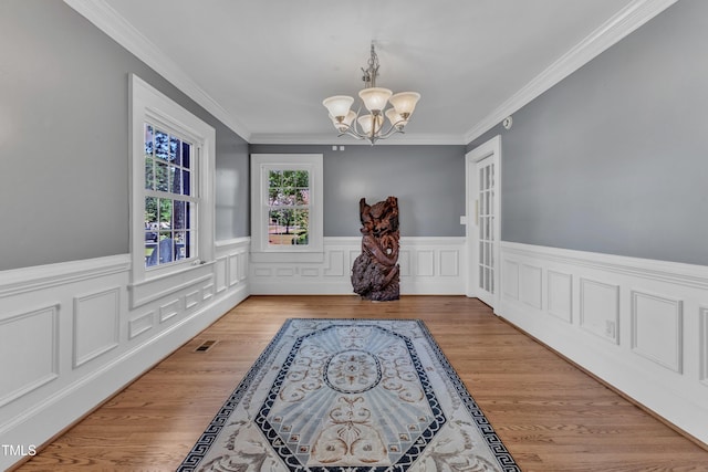 300 S Pine St, Benson, NC 27504 - dining space featuring a chandelier, wainscoting, crown molding, and wood finished floors