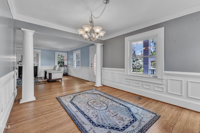 300 S Pine St, Benson, NC 27504 - entryway featuring decorative columns, crown molding, plenty of natural light, wainscoting, and a chandelier