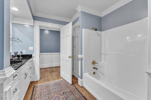 300 S Pine St, Benson, NC 27504 - full bath featuring wood finished floors, vanity, shower / tub combination, ornamental molding, and wainscoting