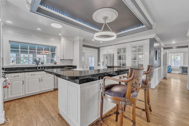300 S Pine St, Benson, NC 27504 - kitchen with stainless steel fridge, crown molding, white cabinetry, light wood finished floors, and recessed lighting